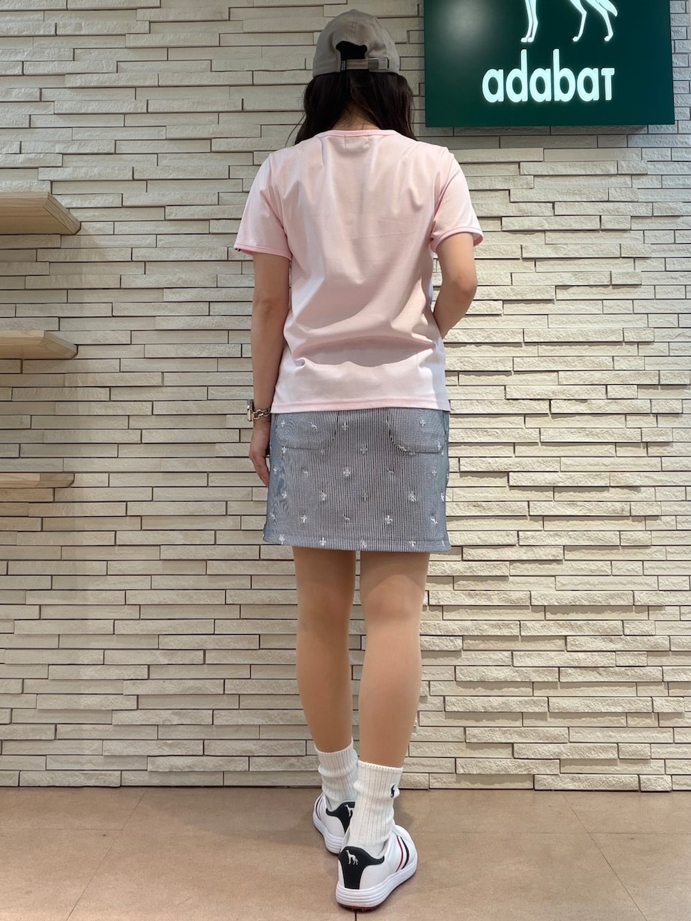 ピンク系のTシャツ/カットソー、ホワイト系のスカート、ホワイト系のゴルフグッズを着用したレディースの夏コーディネートの5枚目の写真