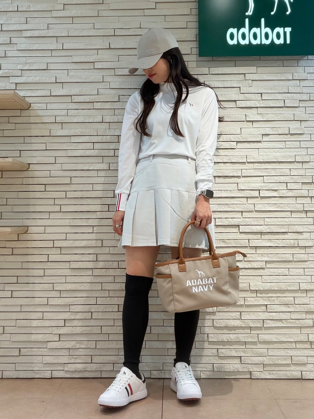 ホワイト系のTシャツ/カットソー、グレー系のスカート、ベージュ系のトートバッグを着用したレディースの秋コーディネートの5枚目の写真