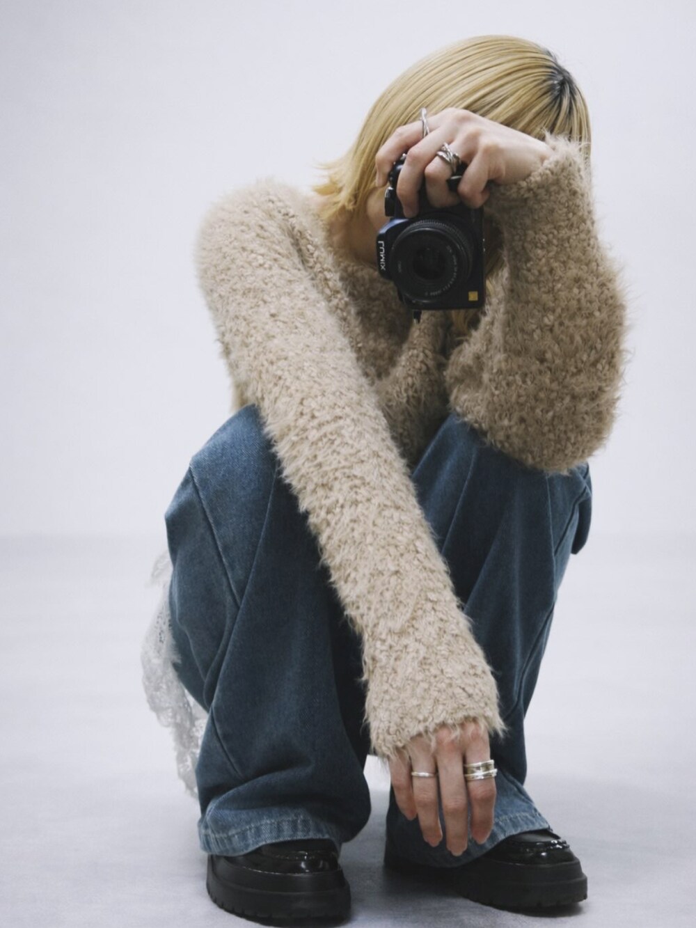 ベージュ系のニット/セーター、ブルー系のデニムパンツ、ブラック系のシューズを着用したレディースの冬コーディネートの2枚目の写真