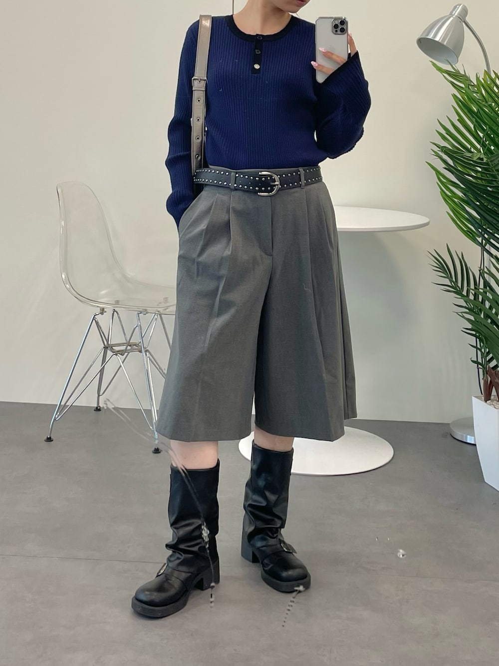 ブラック系のブーツ、その他のショルダーバッグ、グレー系のパンツを着用したレディースの秋コーディネートの2枚目の写真