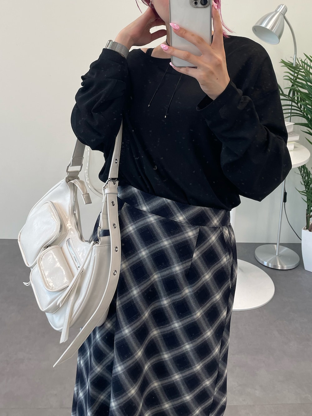 ブラック系のTシャツ/カットソー、ブルー系のスカート、ホワイト系のショルダーバッグを着用したレディースの秋コーディネートの2枚目の写真