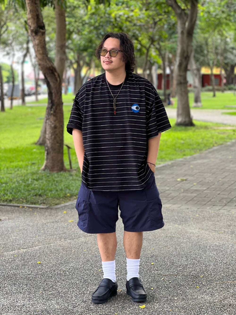 ブラック系のシューズ、ブルー系のカーゴパンツ、ブラック系のTシャツ/カットソーを着用したメンズの夏コーディネートの4枚目の写真