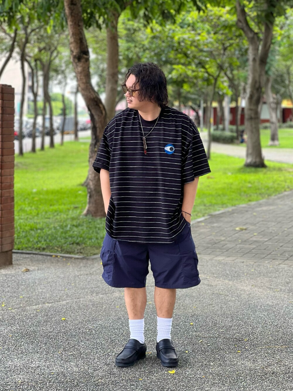 ブラック系のシューズ、ブルー系のカーゴパンツ、ブラック系のTシャツ/カットソーを着用したメンズの夏コーディネートの3枚目の写真