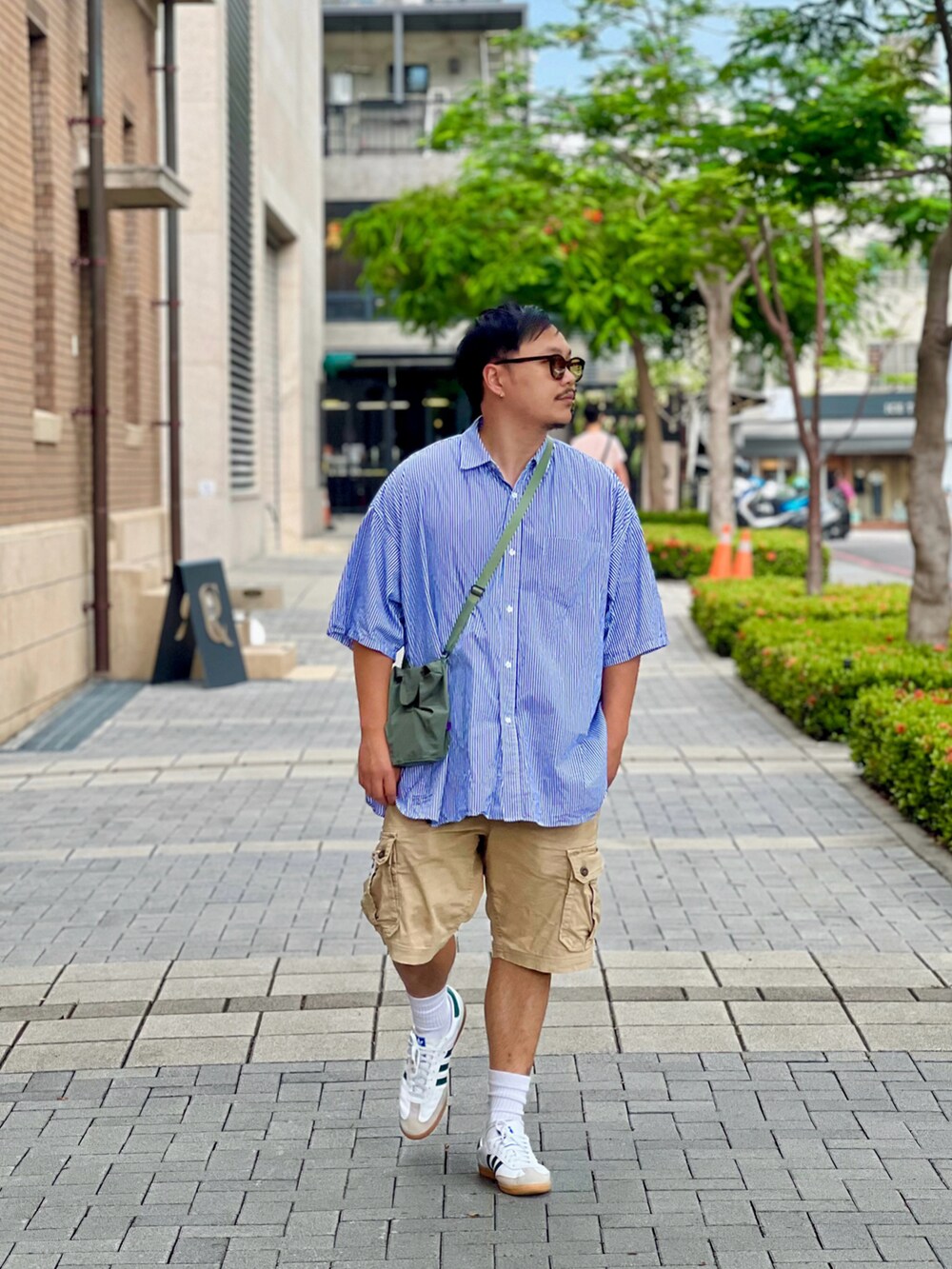 ブルー系のトップス、ベージュ系のパンツ、ホワイト系のスニーカーを着用したメンズの夏コーディネートの2枚目の写真