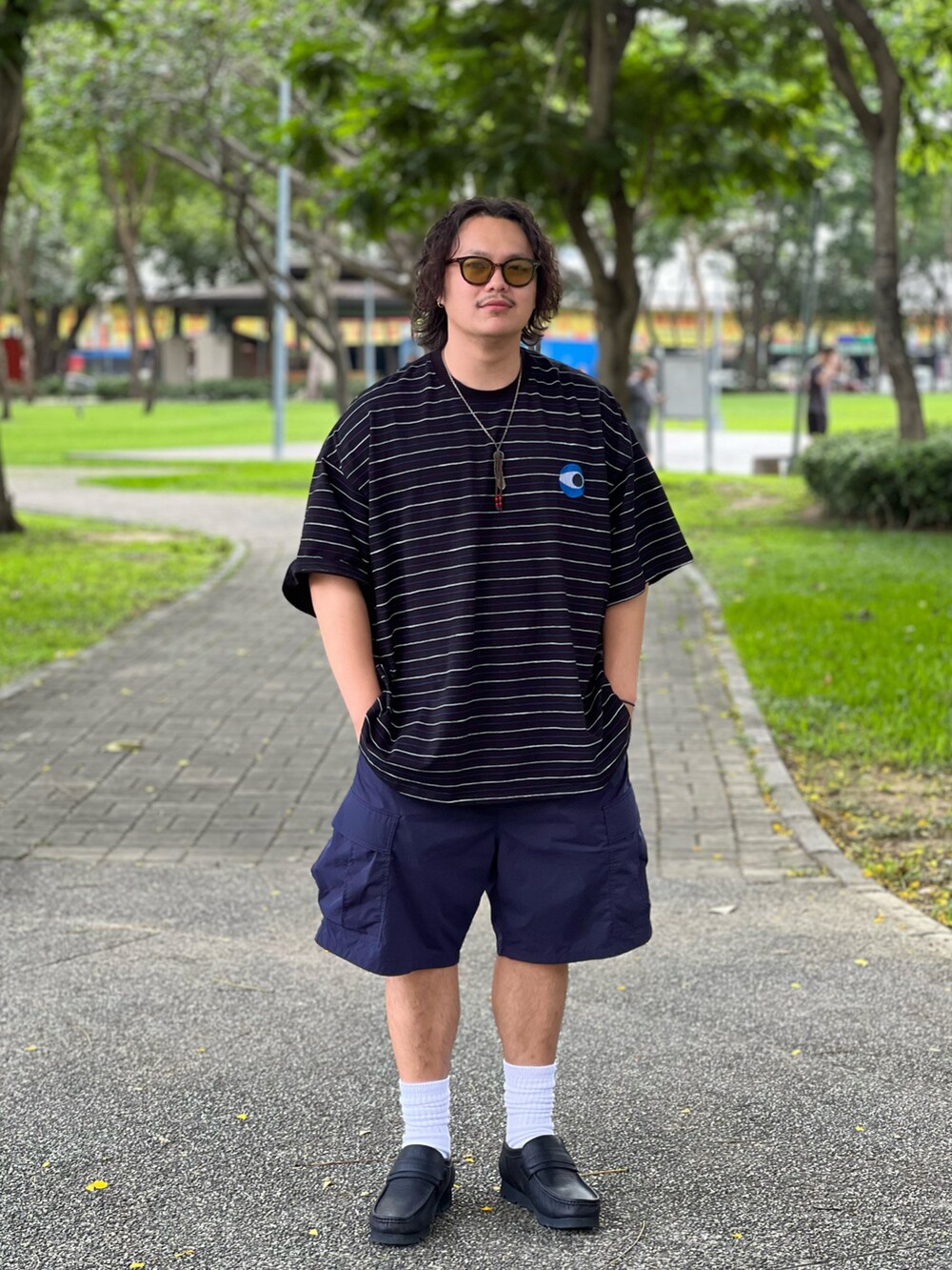 ブラック系のシューズ、ブルー系のカーゴパンツ、ブラック系のTシャツ/カットソーを着用したメンズの夏コーディネートの2枚目の写真