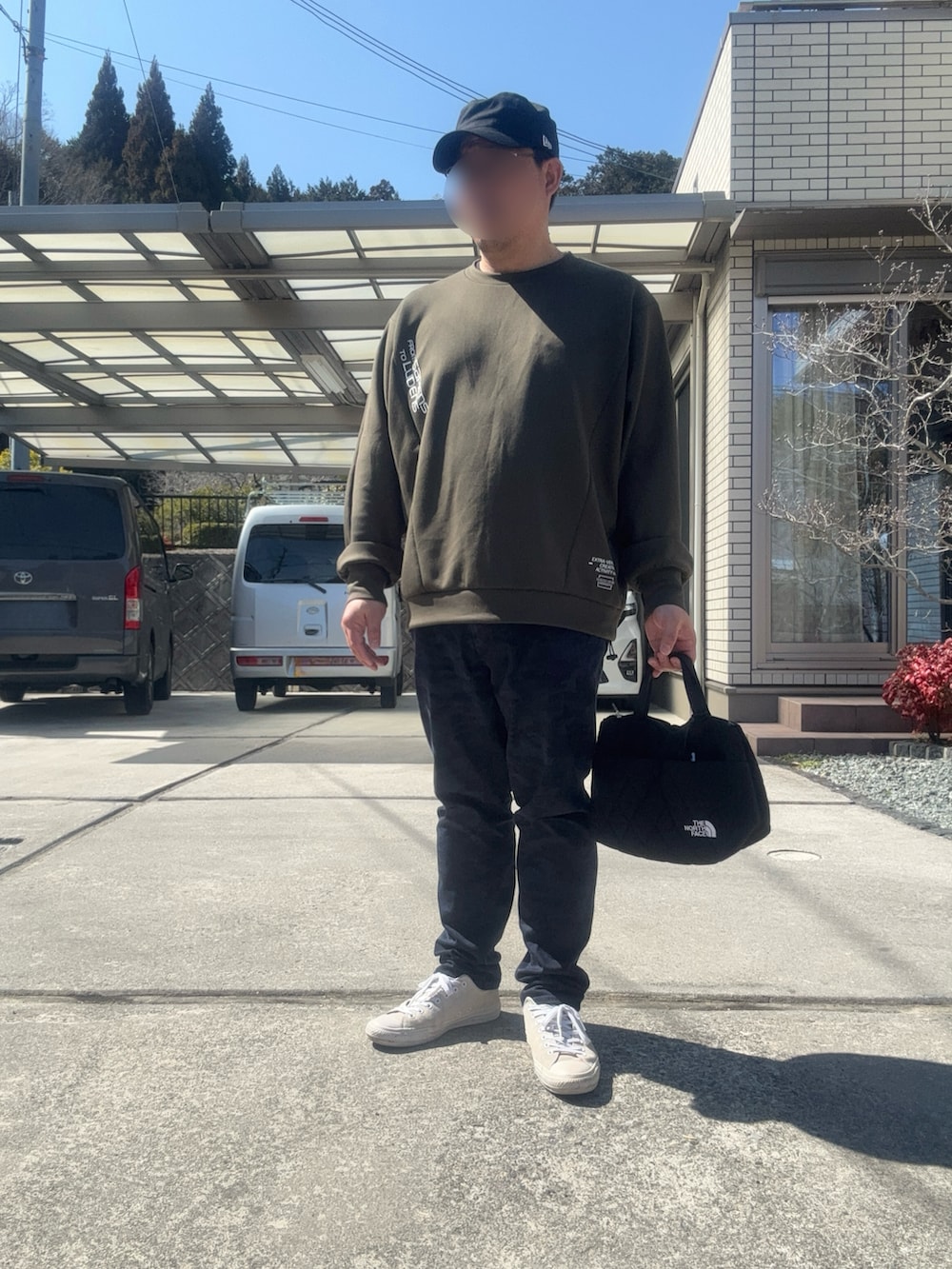 ブルー系のダウンジャケット/コート、ブルー系のチノパンツ、ブラック系のトートバッグを着用したメンズの秋コーディネートの2枚目の写真