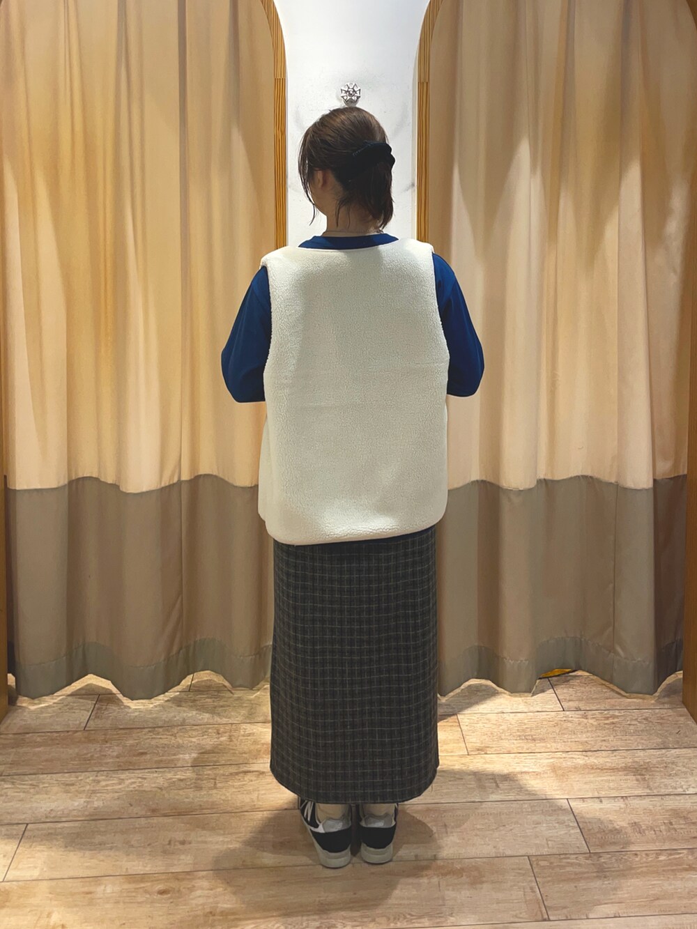 グレー系のスカート、グレー系のハンドバッグ、ブルー系のTシャツ/カットソーを着用したレディースの秋コーディネートの2枚目の写真