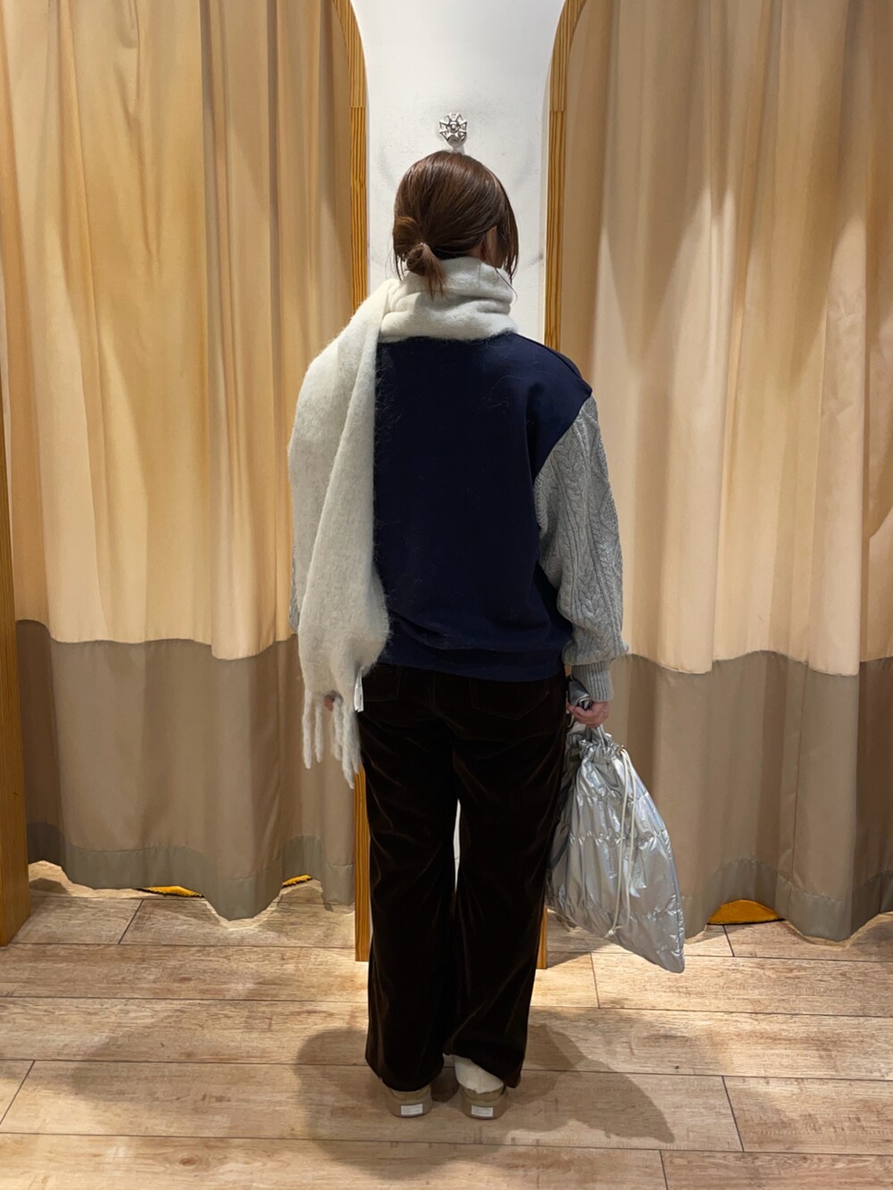 ホワイト系のハンドバッグ、ブラウン系のその他パンツ、ブルー系のTシャツ/カットソーを着用したレディースの秋コーディネートの2枚目の写真