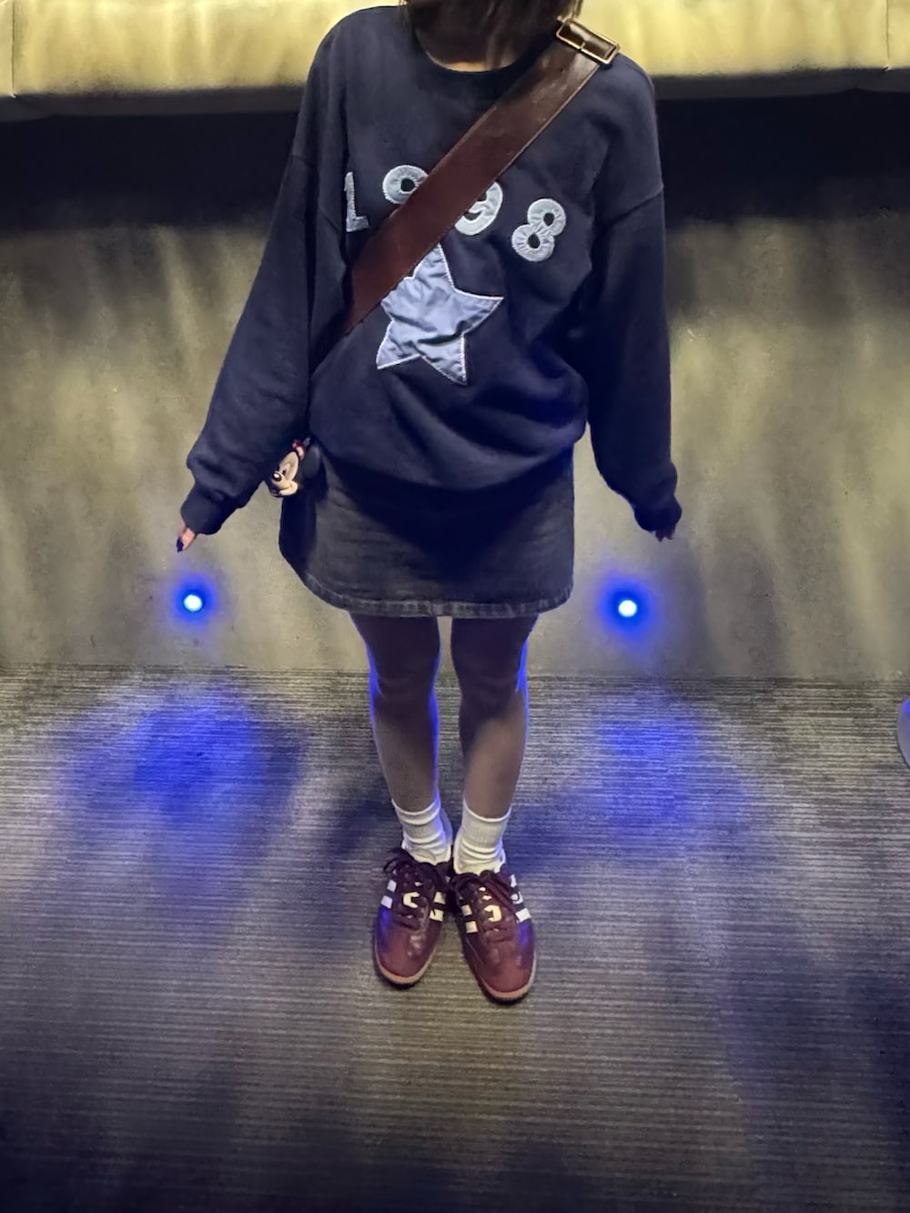 ブラウン系のボストンバッグ、ブルー系のスウェット、グレー系のデニムスカートを着用したレディースの秋コーディネートの2枚目の写真