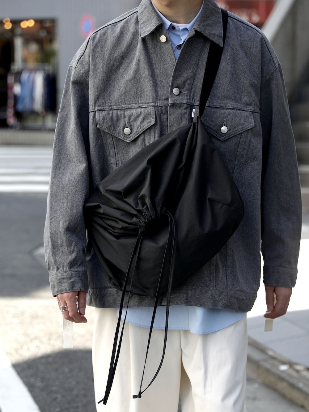 グレー系のデニムジャケット、ホワイト系のその他パンツ、ブルー系のスニーカーを着用したメンズの冬コーディネートの5枚目の写真