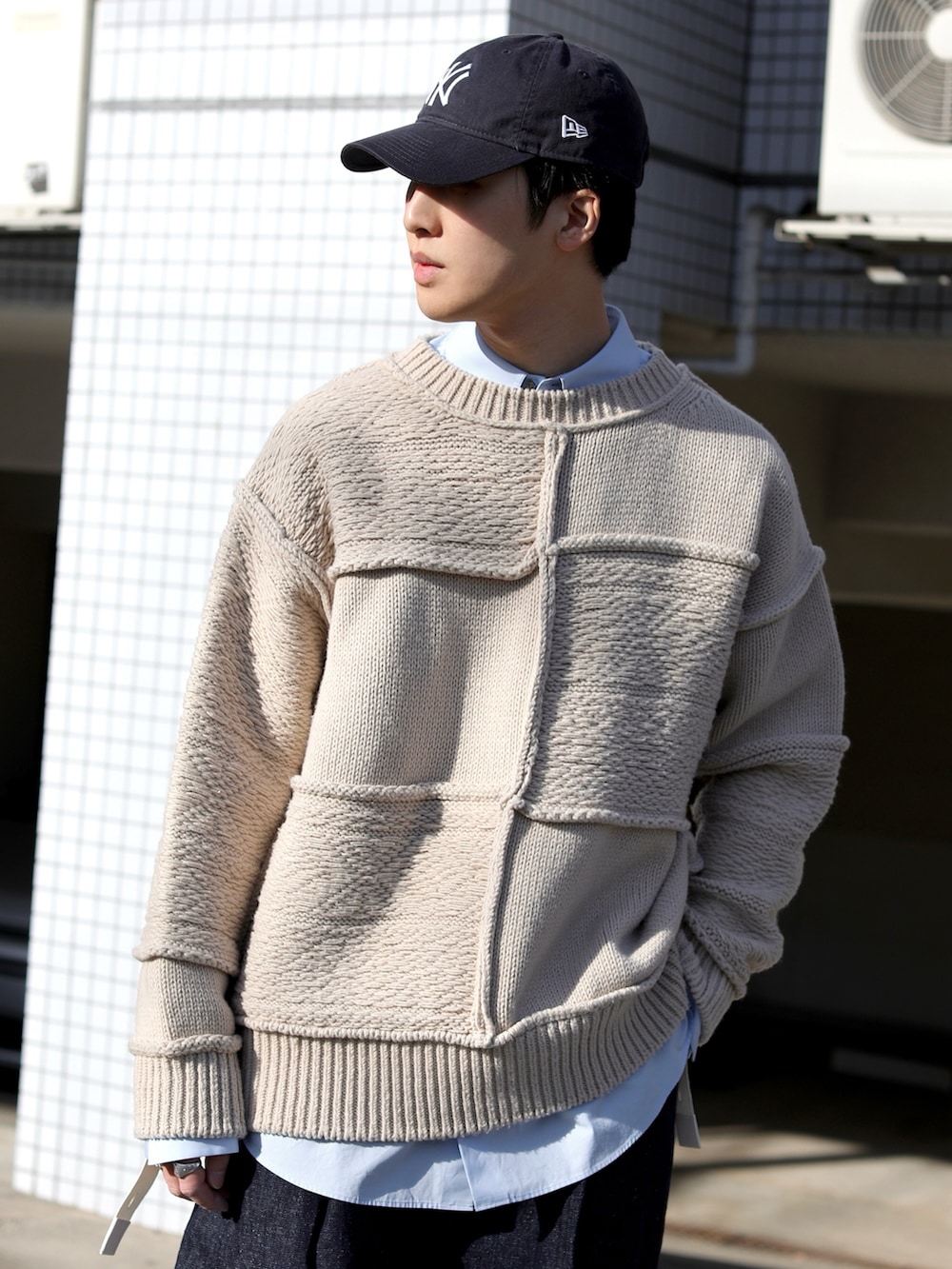 ブルー系のデニムパンツ、ブルー系のスニーカー、ベージュ系のニット/セーターを着用したメンズの冬コーディネートの3枚目の写真