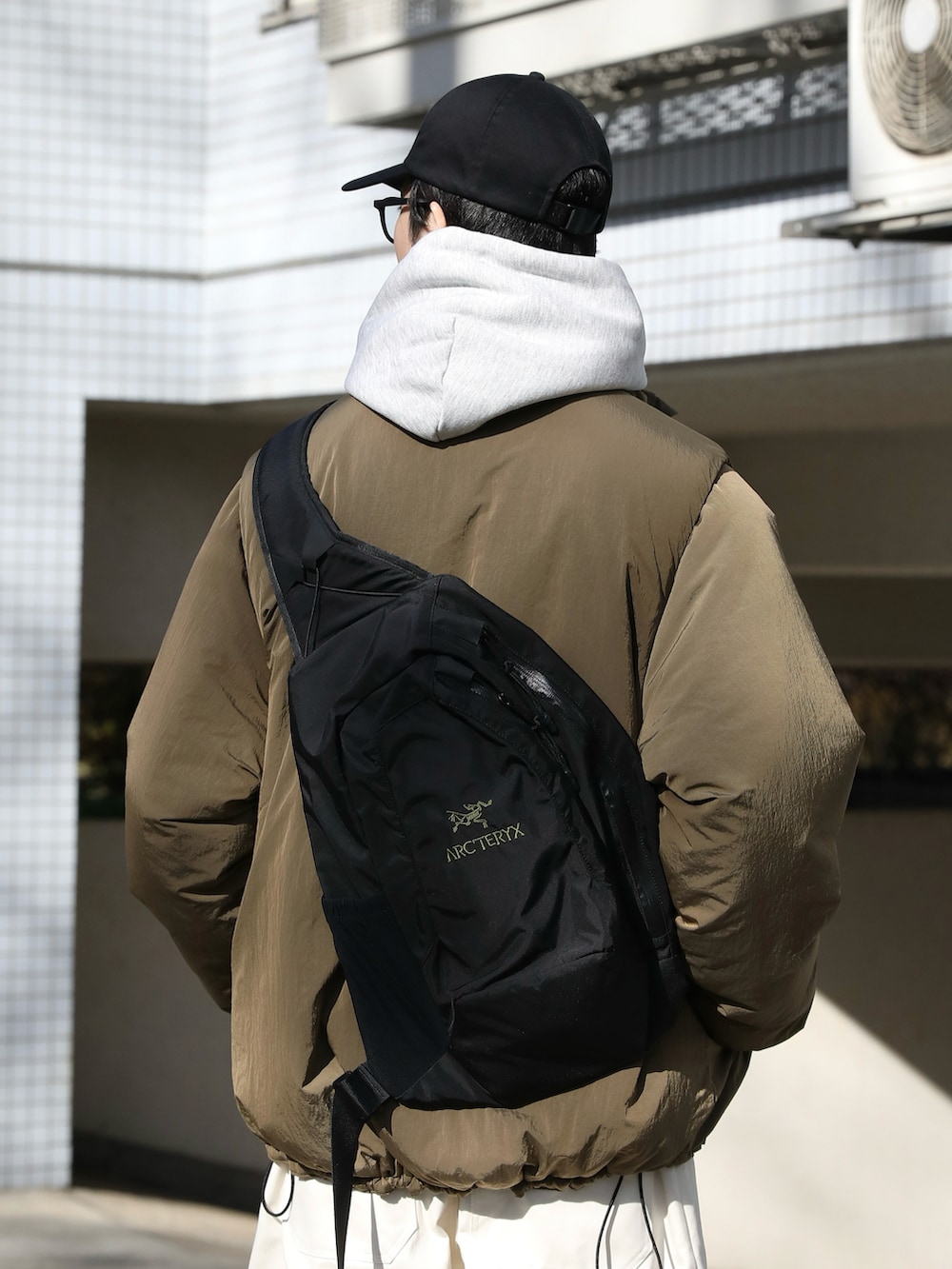 ベージュ系のジャケット/アウター、グレー系のパーカー、ホワイト系のチノパンツを着用したメンズの冬コーディネートの4枚目の写真