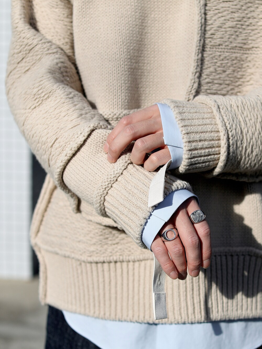 ブルー系のデニムパンツ、ブルー系のスニーカー、ベージュ系のニット/セーターを着用したメンズの冬コーディネートの5枚目の写真