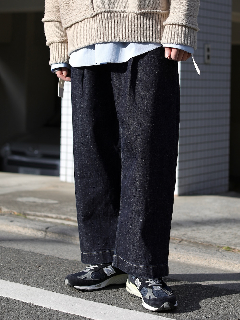 ブルー系のデニムパンツ、ブルー系のスニーカー、ベージュ系のニット/セーターを着用したメンズの冬コーディネートの4枚目の写真