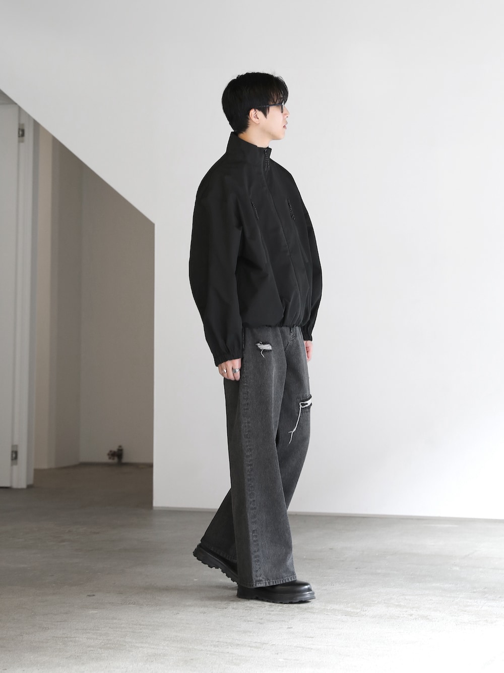 ブラック系のその他アウター、ブラック系のブーツを着用したメンズの秋コーディネートの2枚目の写真