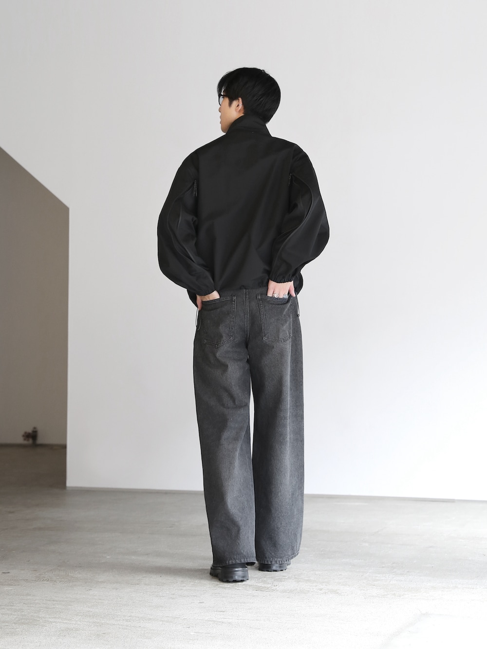 ブラック系のその他アウター、ブラック系のブーツを着用したメンズの秋コーディネートの3枚目の写真