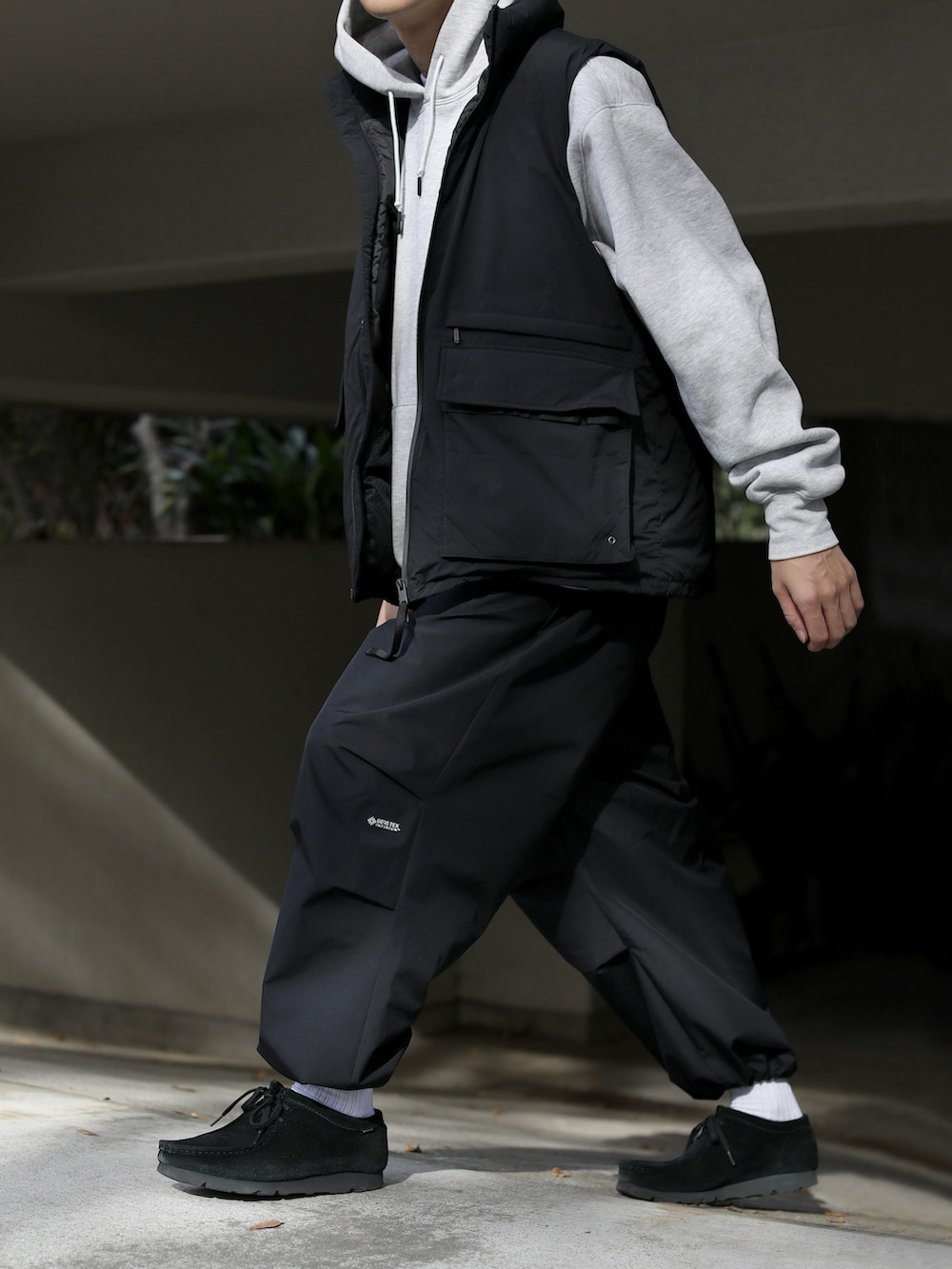 グレー系のパーカー、ブラック系のジャケット/アウター、ブラック系のパンツを着用したメンズの秋コーディネートの4枚目の写真