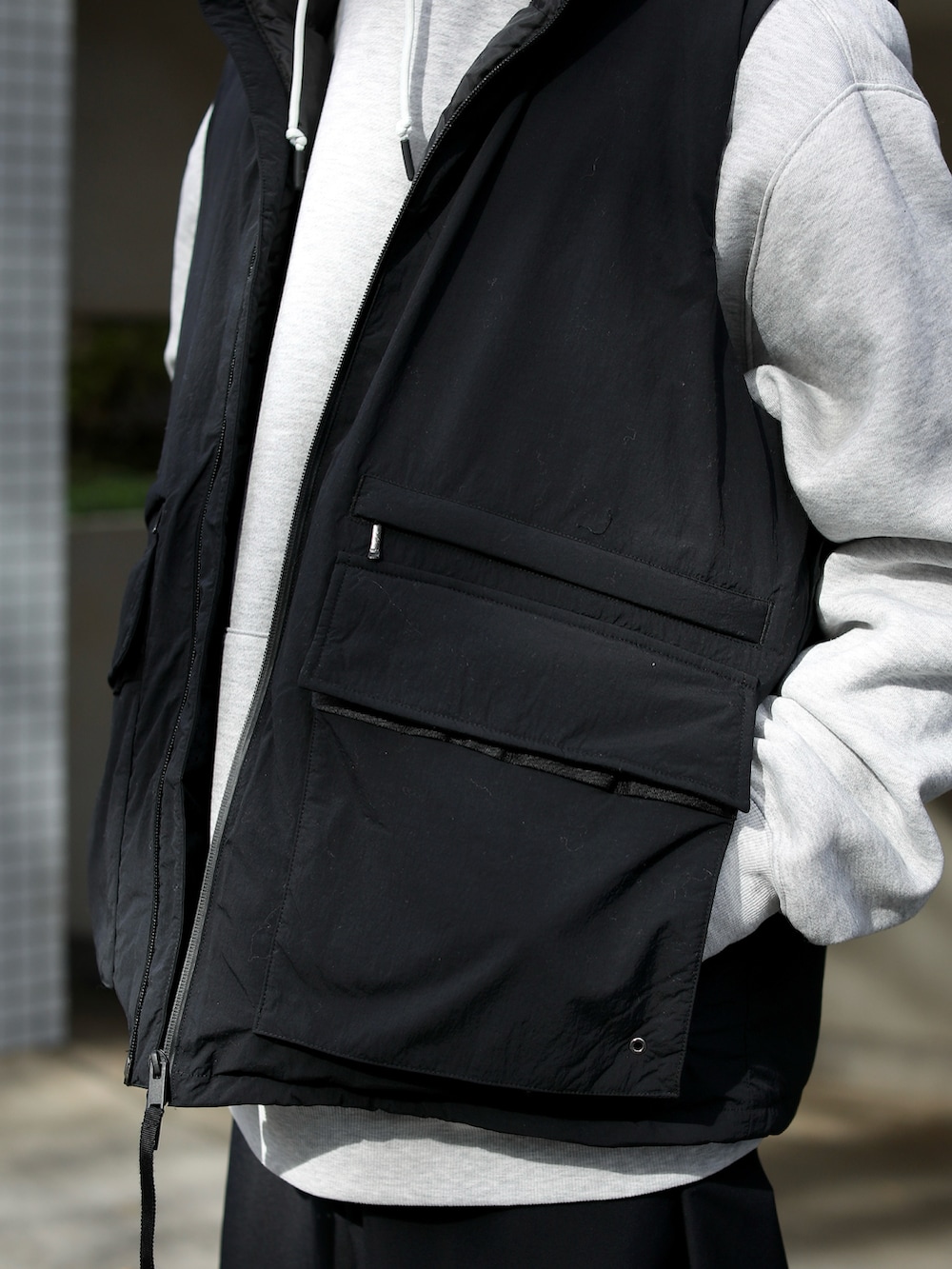 グレー系のパーカー、ブラック系のジャケット/アウター、ブラック系のパンツを着用したメンズの秋コーディネートの5枚目の写真