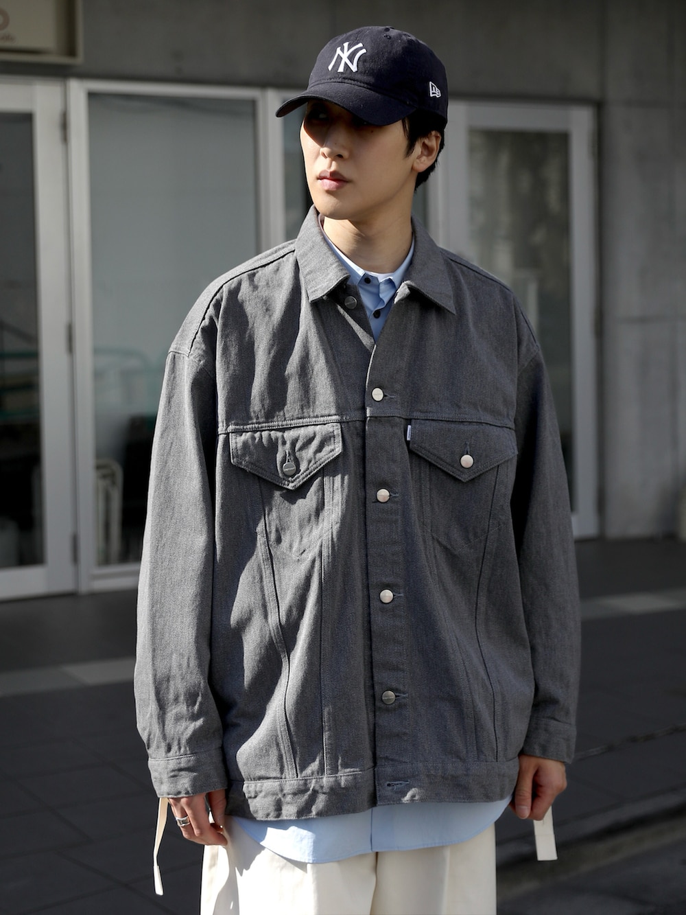 グレー系のデニムジャケット、ホワイト系のその他パンツ、ブルー系のスニーカーを着用したメンズの冬コーディネートの3枚目の写真