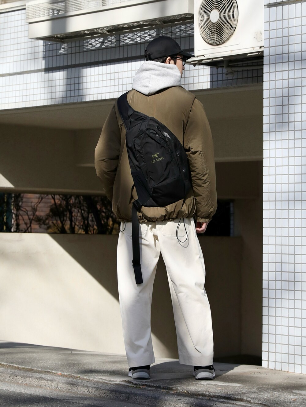 ベージュ系のジャケット/アウター、グレー系のパーカー、ホワイト系のチノパンツを着用したメンズの冬コーディネートの2枚目の写真