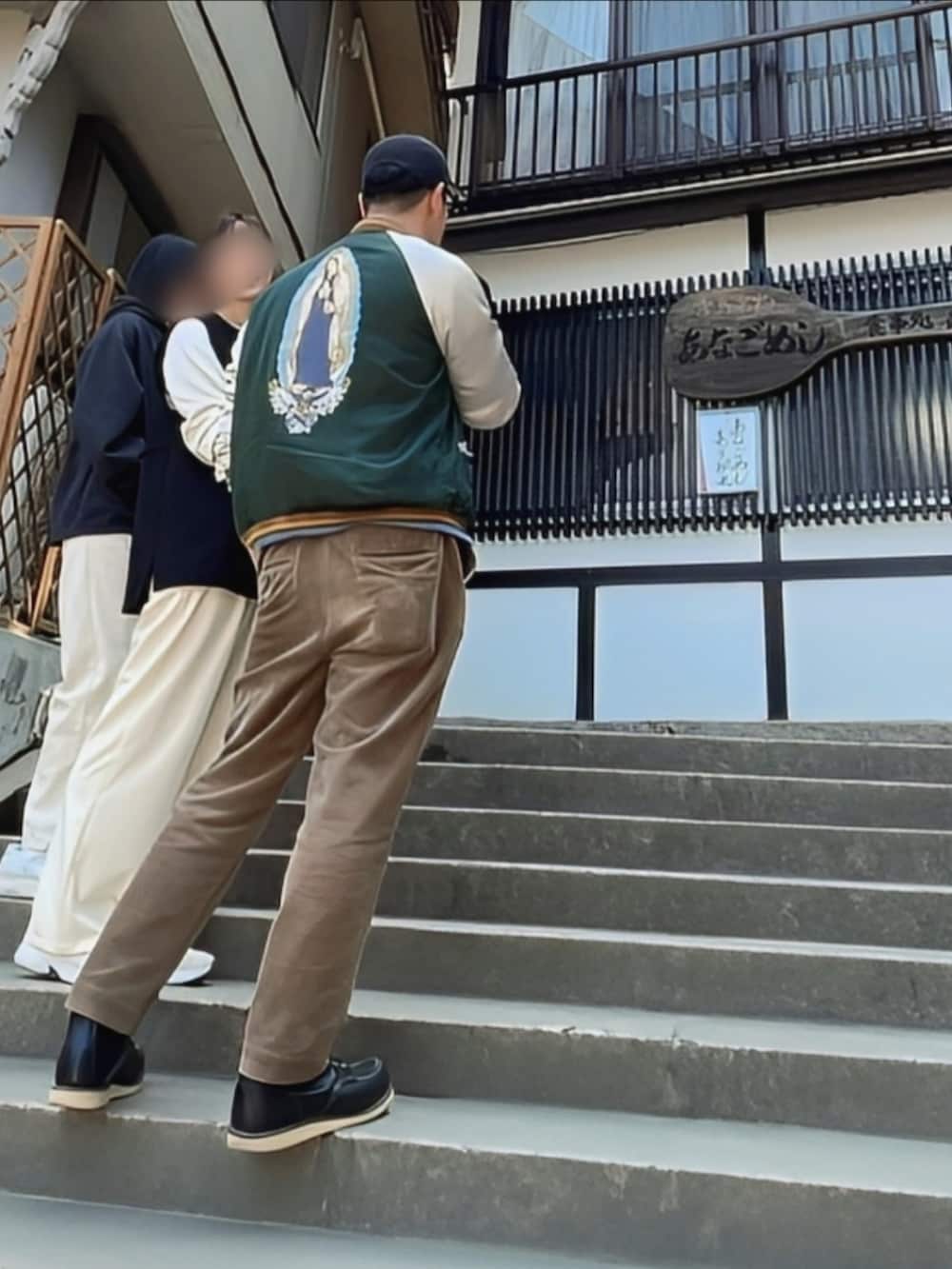 ブラウン系のその他パンツ、グリーン系のスカジャン、ブラック系のブーツを着用したメンズの春コーディネートの2枚目の写真