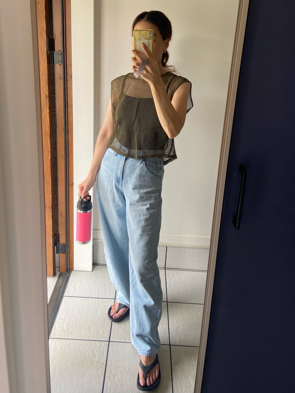 ブルー系のデニムパンツ、ピンク系の水筒を着用したレディースの夏コーディネートの2枚目の写真