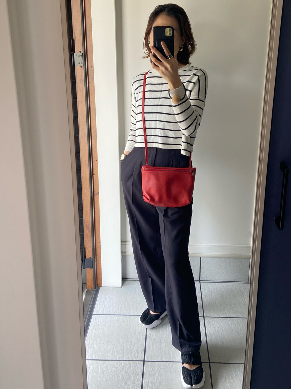 ブルー系のシャツ/ブラウス、ブラック系のスラックス、ブラック系のスニーカーを着用したレディースの春コーディネートの2枚目の写真