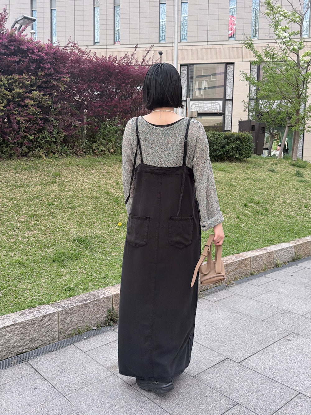 ブラック系のワンピース、ブラック系のニット/セーター、シルバー系のネックレスを着用したレディースの夏コーディネートの2枚目の写真