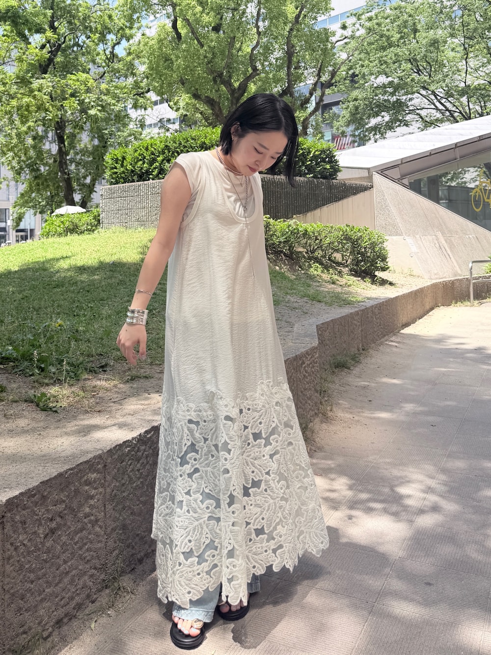 ホワイト系のワンピース、ブルー系のデニムパンツ、ホワイト系のTシャツ/カットソーを着用したレディースの夏コーディネートの2枚目の写真
