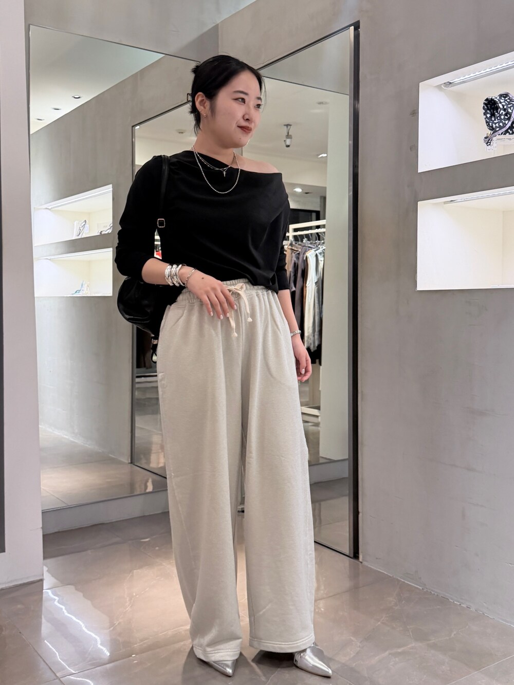 ホワイト系のスウェットパンツ、ブラック系のTシャツ/カットソー、ブラック系のトートバッグを着用したレディースの秋コーディネートの2枚目の写真