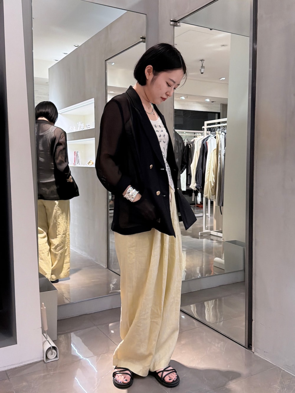 イエロー系のその他パンツ、ブラック系のテーラードジャケット、ホワイト系のストール/ショールを着用したレディースの夏コーディネートの2枚目の写真