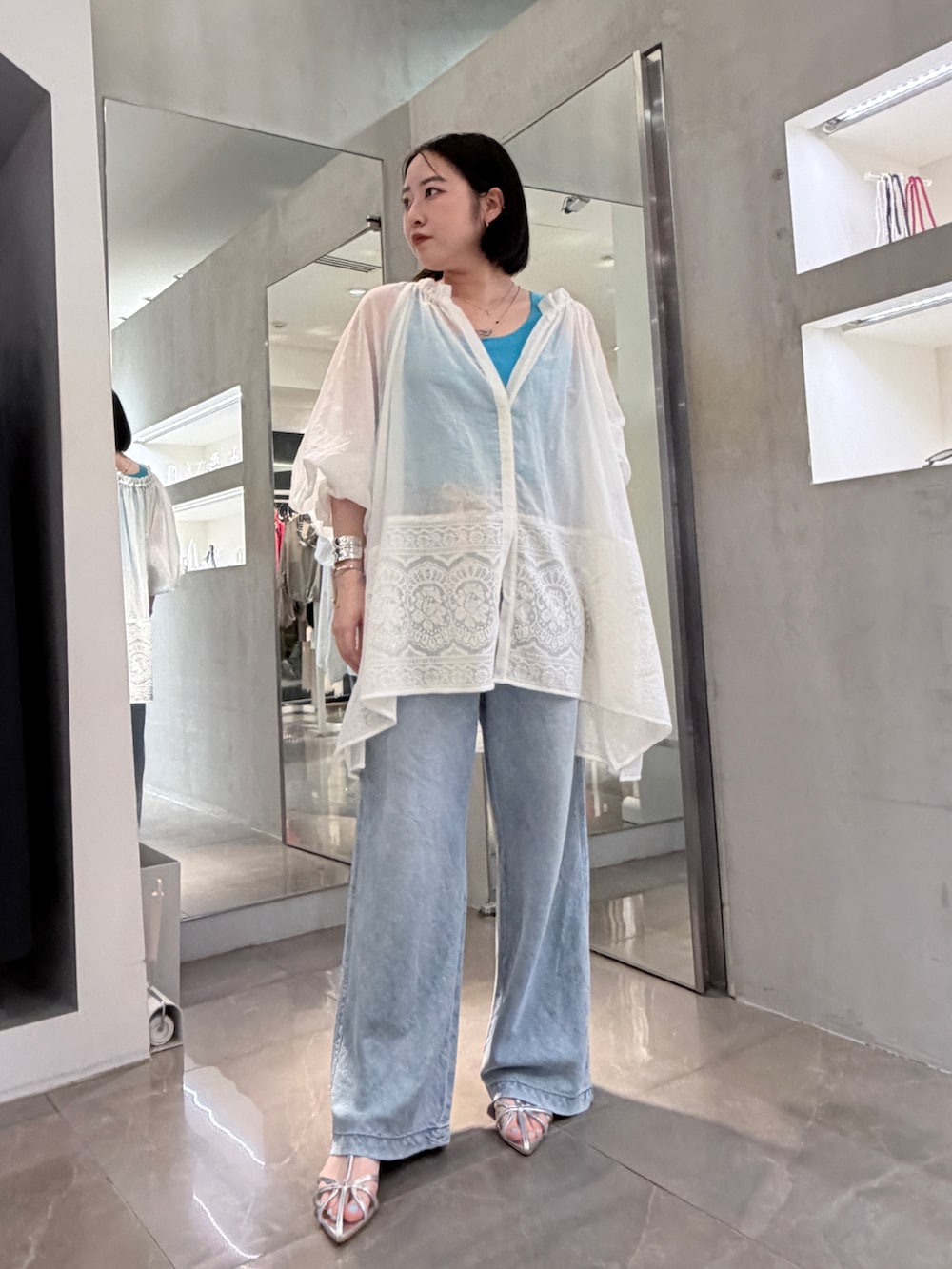 ホワイト系のシャツ/ブラウス、ブルー系のデニムパンツ、シルバー系のその他シューズを着用したレディースの夏コーディネートの2枚目の写真