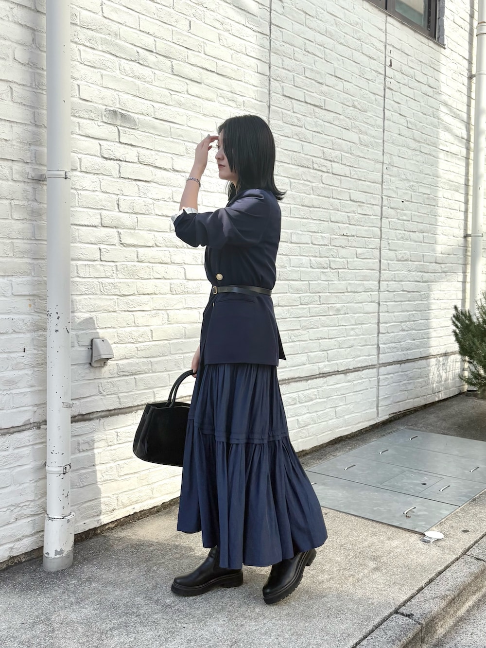 ブルー系のテーラードジャケット、ブルー系のワンピース、ブラック系のブーツを着用したレディースの秋コーディネートの3枚目の写真