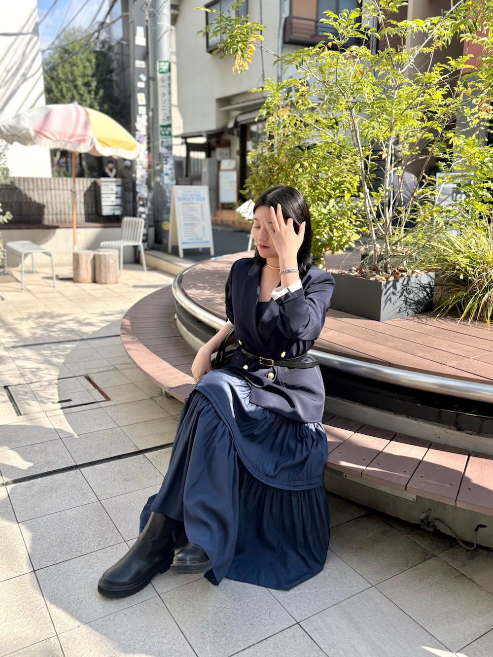 ブルー系のテーラードジャケット、ブルー系のワンピース、ブラック系のブーツを着用したレディースの秋コーディネートの4枚目の写真