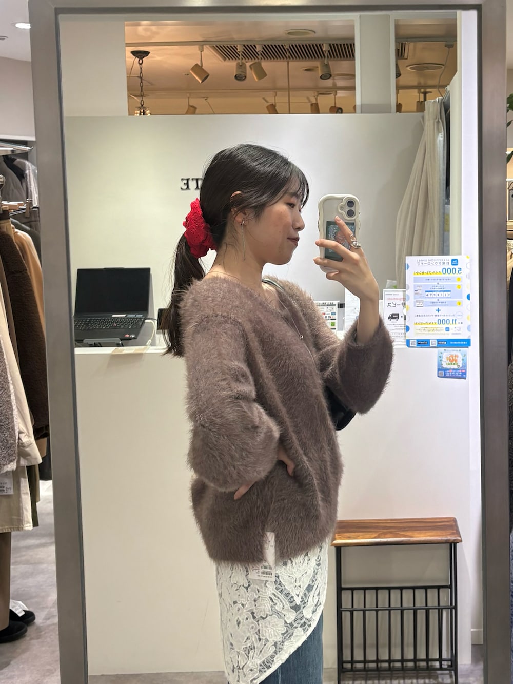 ブラウン系のニット/セーター、ブルー系のデニムパンツ、ブラック系のハンドバッグを着用したレディースの秋コーディネートの3枚目の写真