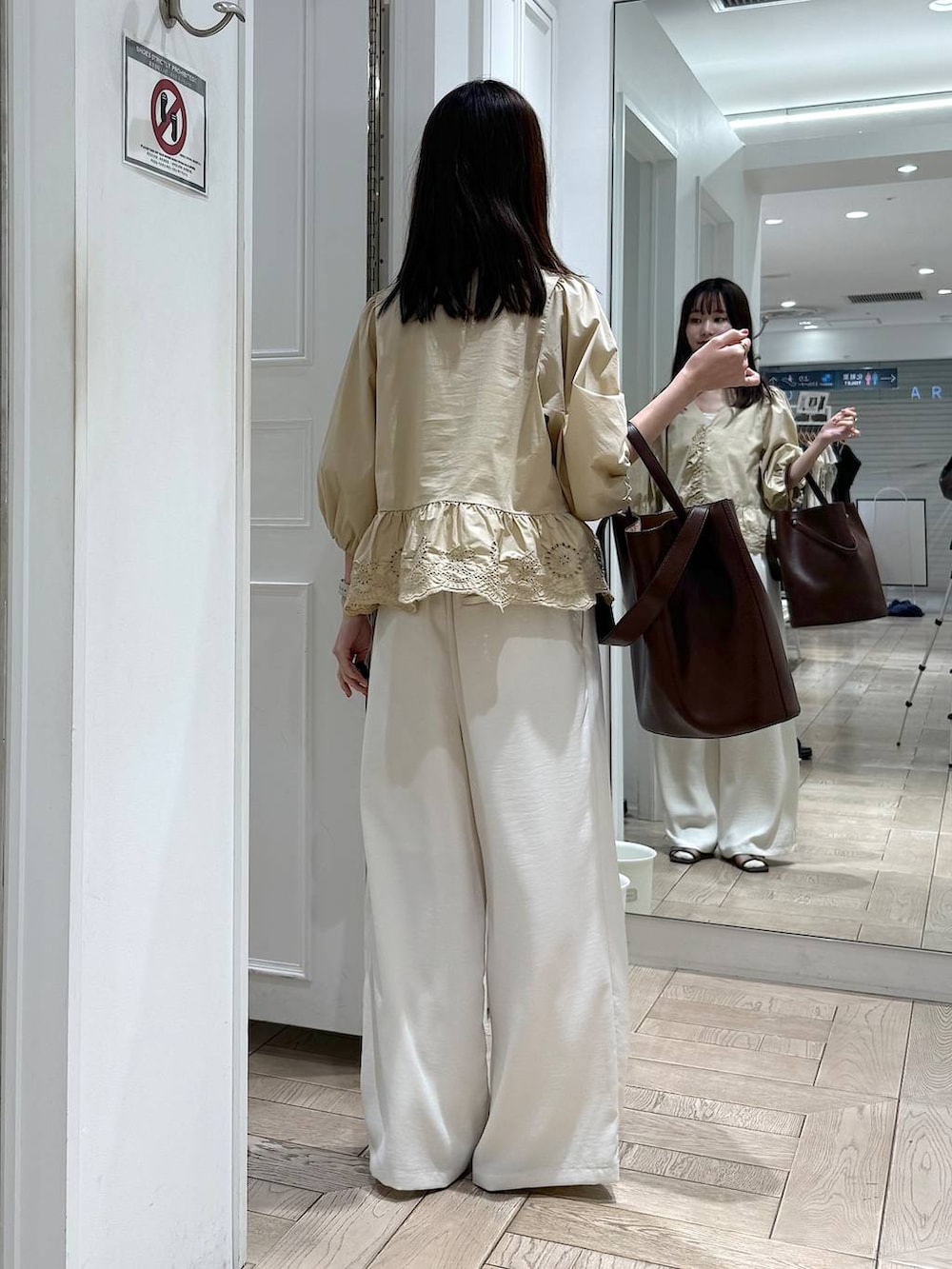 ベージュ系のシャツ/ブラウス、ホワイト系のその他パンツ、ブラウン系のトートバッグを着用したレディースの春コーディネートの3枚目の写真