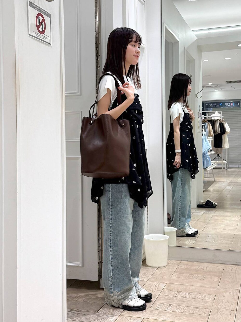 ブルー系のデニムパンツ、ホワイト系のTシャツ/カットソー、ホワイト系のサンダルを着用したレディースの夏コーディネートの2枚目の写真