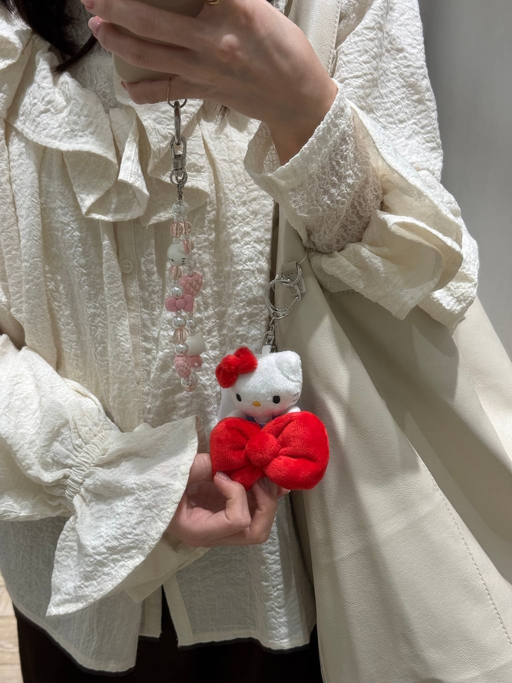 ホワイト系のキーホルダー、グレー系のキーホルダー、レッド系のキーホルダーを着用したレディースの冬コーディネートの2枚目の写真