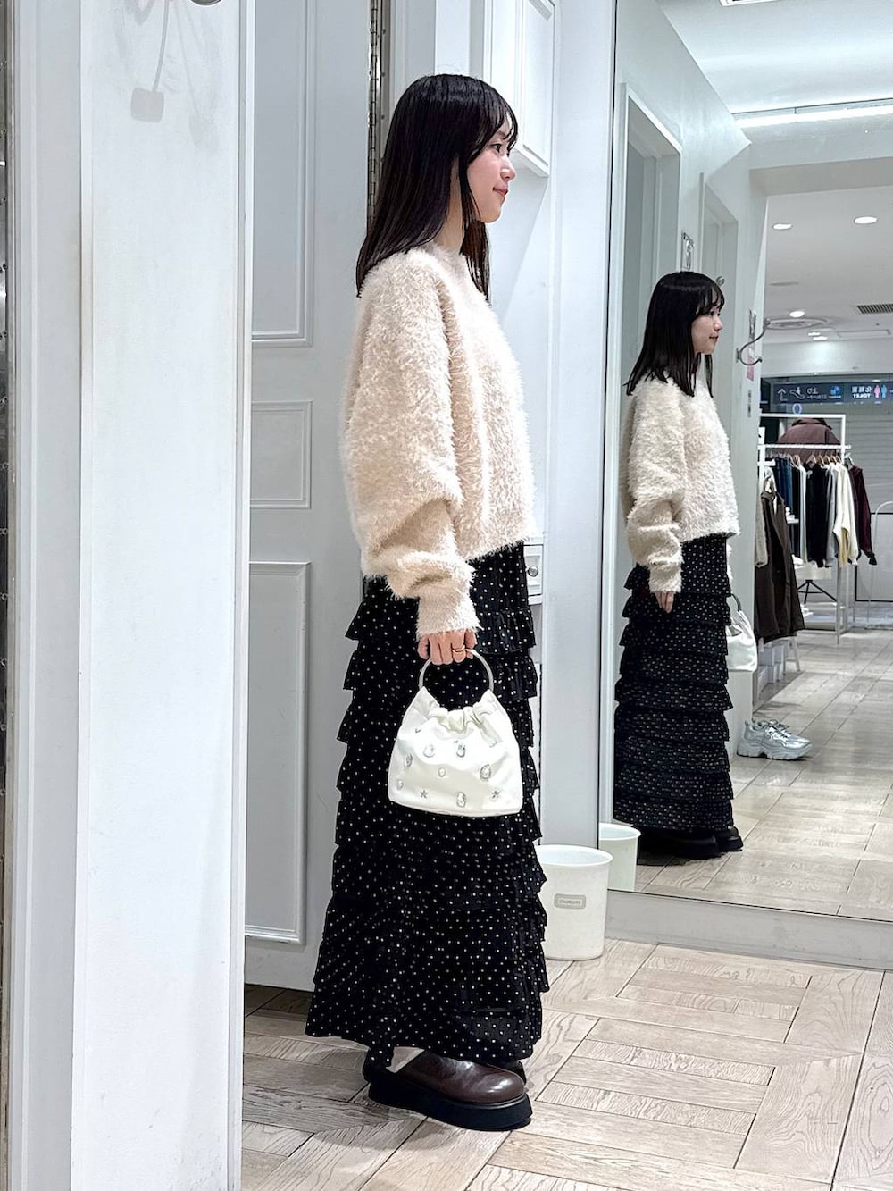 その他のスカート、ブラウン系のサンダル、ホワイト系のハンドバッグを着用したレディースの冬コーディネートの2枚目の写真