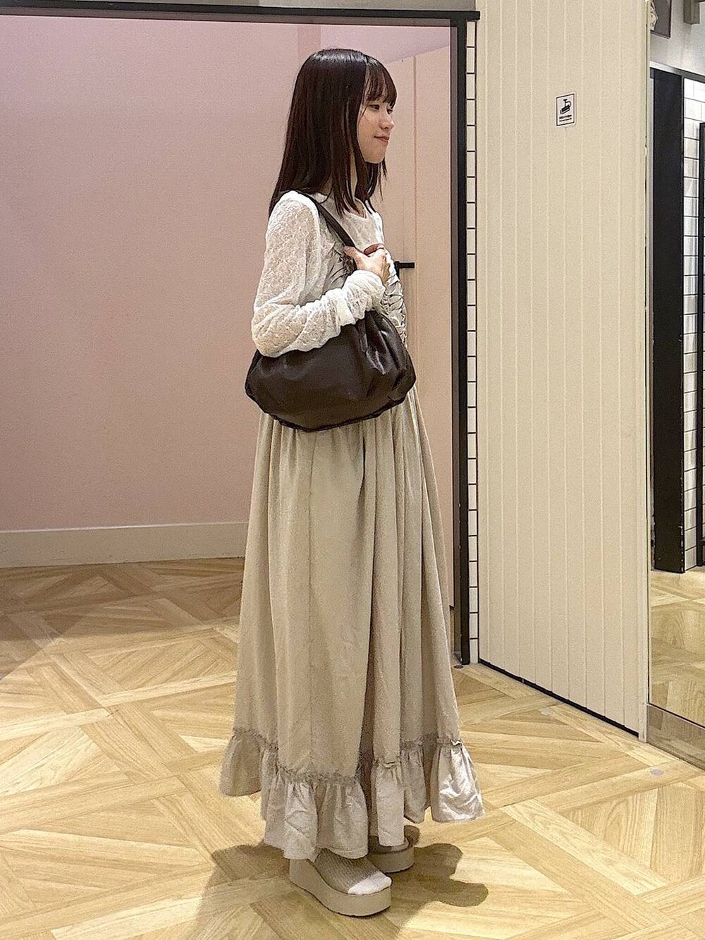 ブラウン系のボストンバッグ、ホワイト系のTシャツ/カットソー、ホワイト系のサンダルを着用したレディースの夏コーディネートの2枚目の写真