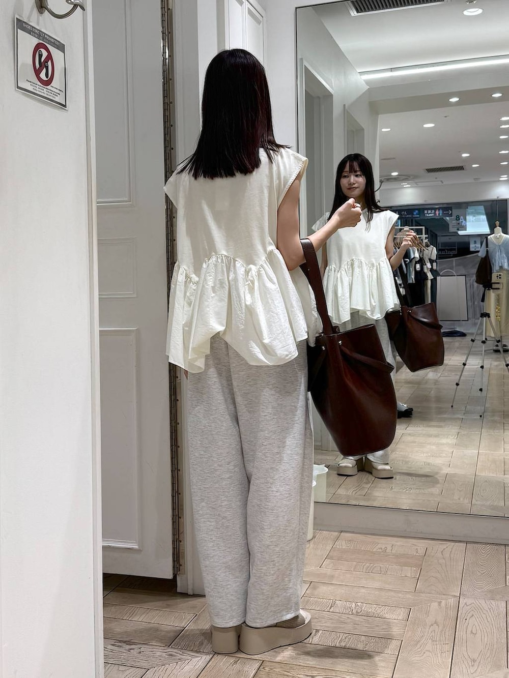 ホワイト系のTシャツ/カットソー、グレー系のスウェットパンツ、ホワイト系のサンダルを着用したレディースの夏コーディネートの3枚目の写真