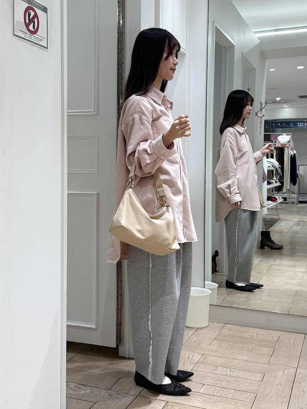 グレー系のスウェットパンツ、ピンク系のシャツ/ブラウス、ベージュ系のショルダーバッグを着用したレディースの冬コーディネートの2枚目の写真