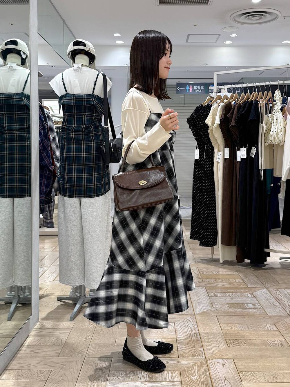 ブラウン系のボストンバッグ、ホワイト系のTシャツ/カットソー、グレー系のワンピースを着用したレディースの秋コーディネートの2枚目の写真