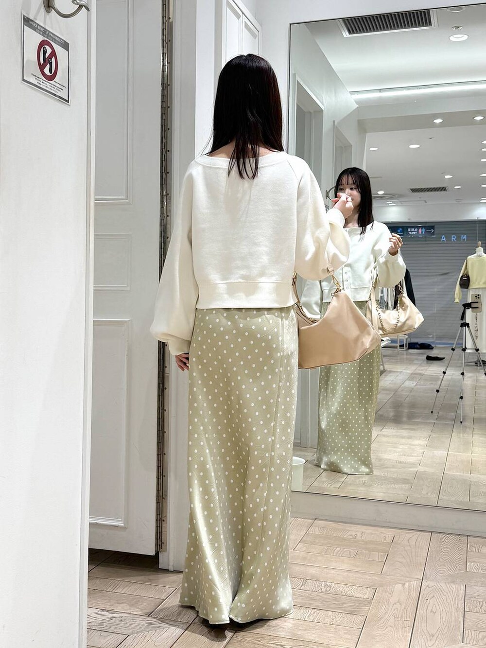 ベージュ系のスカート、ベージュ系のショルダーバッグ、ブラウン系のサンダルを着用したレディースの春コーディネートの3枚目の写真