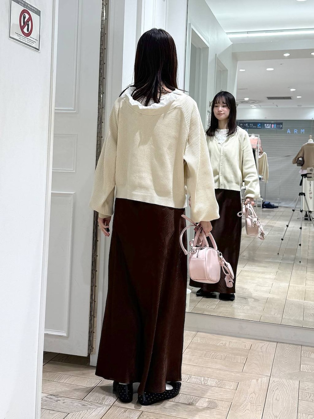 ブラウン系のスカート、ブラック系のパンプス、ピンク系のボストンバッグを着用したレディースの冬コーディネートの3枚目の写真