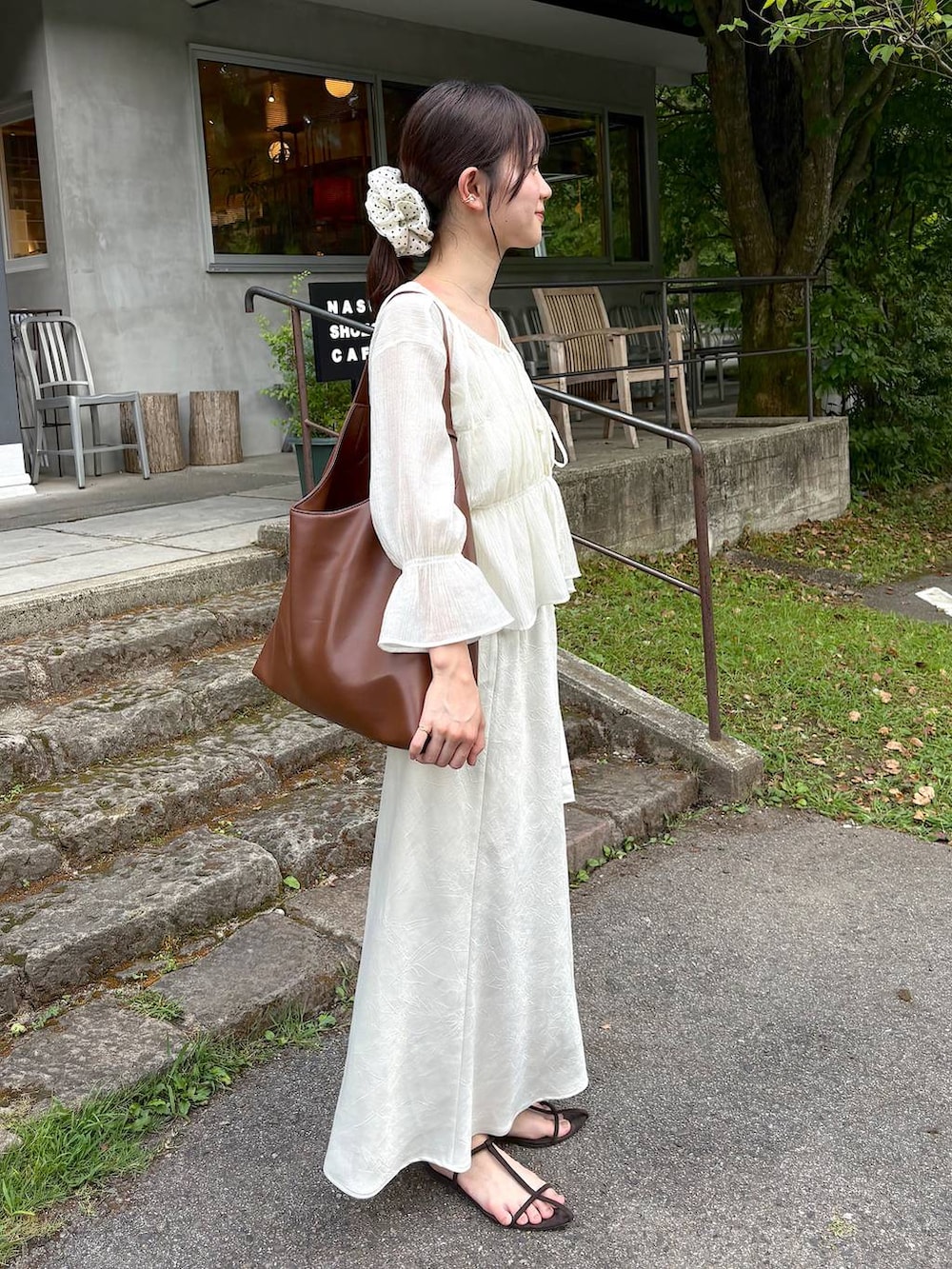 ブラウン系のサンダル、ホワイト系のシャツ/ブラウス、ホワイト系のスカートを着用したレディースの秋コーディネートの2枚目の写真