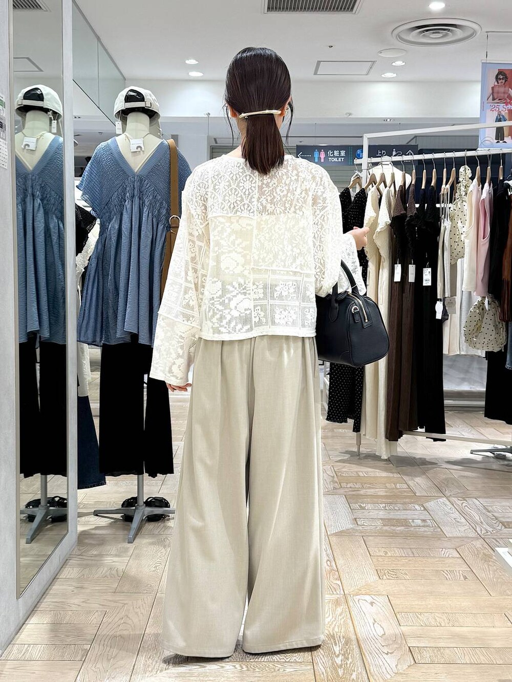 ブラック系のショルダーバッグ、ホワイト系のカーディガン/ボレロ、ゴールド系のバレッタ/ヘアクリップを着用したレディースの秋コーディネートの3枚目の写真