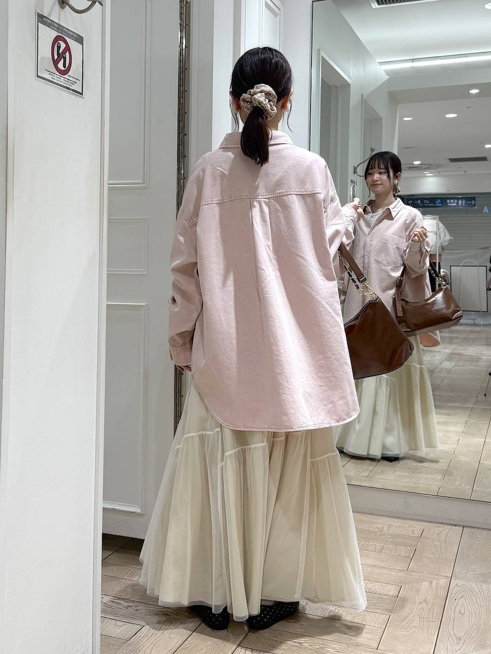 ブラック系のパンプス、ピンク系のシャツ/ブラウス、ブラウン系のショルダーバッグを着用したレディースの冬コーディネートの3枚目の写真