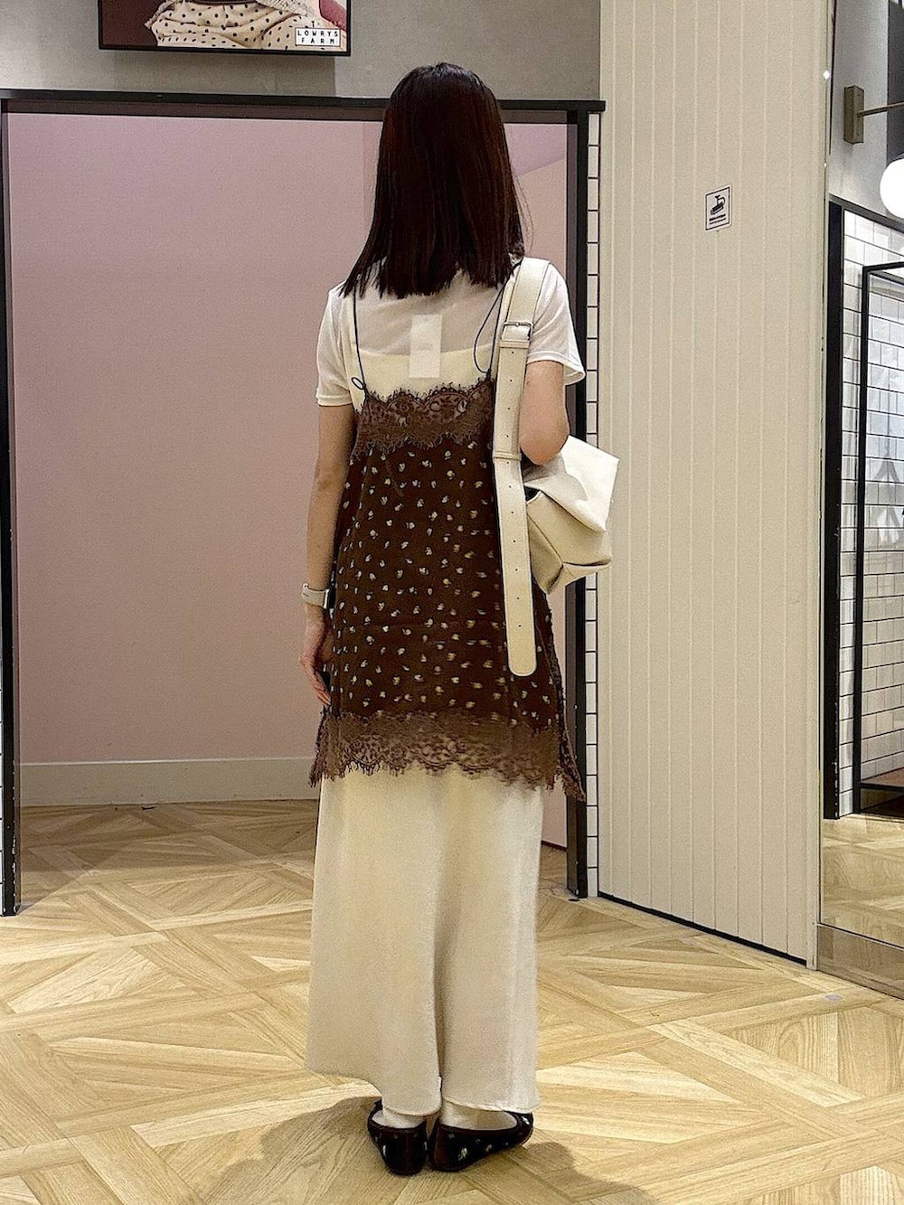 ホワイト系のショルダーバッグ、ブラウン系のバレエシューズ、ブラウン系のキャミソールを着用したレディースの夏コーディネートの3枚目の写真