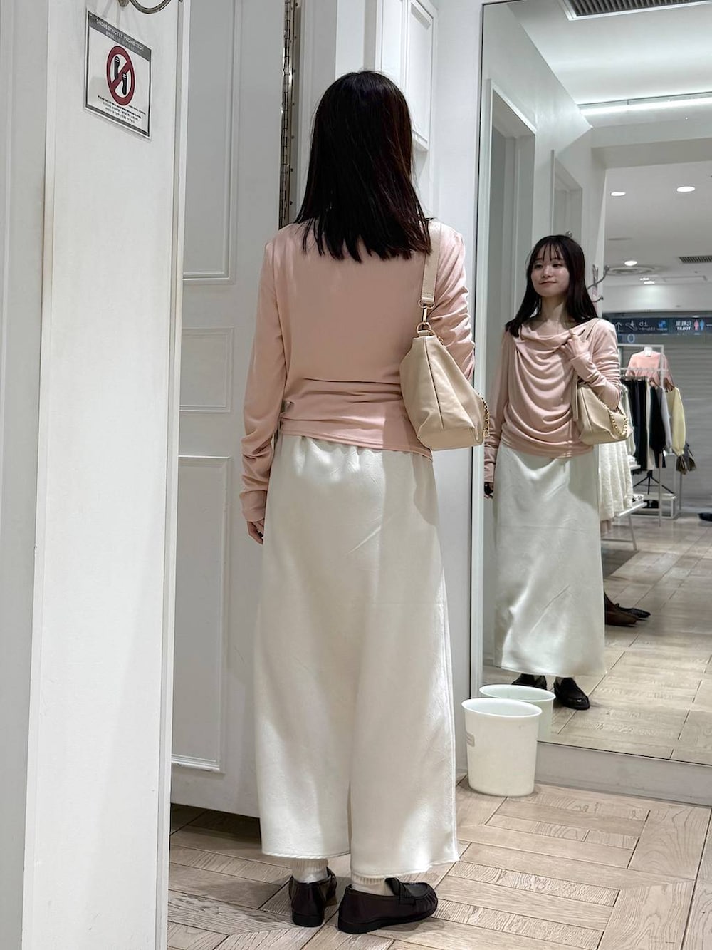 ホワイト系のスカート、ベージュ系のショルダーバッグ、ブラウン系のローファーを着用したレディースの冬コーディネートの3枚目の写真